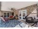 Cozy covered patio featuring a ceiling fan, outdoor seating, brick accents and access to the pool at 30 Capistrano Dr, Ormond Beach, FL 32176