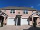 Inviting townhome exterior featuring a pink facade, arched garage entrance, and neat landscaping at 3337 Soho St # 205, Orlando, FL 32835