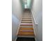 Carpeted staircase leading upstairs featuring a wood handrail and white trim at 3337 Soho St # 205, Orlando, FL 32835