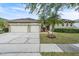 Charming single-Gathering home featuring a three-car garage, landscaped yard, and mature trees at 339 Hammock Dunes Pl, Orlando, FL 32828