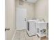 Well-lit laundry room with white washer, sink, tile floors, and access to exterior at 339 Hammock Dunes Pl, Orlando, FL 32828