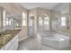 Spa-like bathroom with a soaking tub, granite countertops, a separate shower, and ample mirror space at 339 Hammock Dunes Pl, Orlando, FL 32828