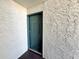 Inviting condo front door features unit number and offers a secure entrance, complemented by textured walls at 4405 S Semoran Blvd # 4, Orlando, FL 32822