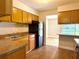 Functional kitchen featuring wood cabinets, black appliances, and granite countertops, perfect for culinary adventures at 4405 S Semoran Blvd # 4, Orlando, FL 32822
