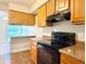 Practical kitchen with wooden cabinets, granite countertops, and modern appliances, ready for home-cooked meals at 4405 S Semoran Blvd # 4, Orlando, FL 32822