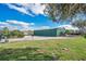 Property with gravel parking, lawn and large metal barn with beautiful skies and green grass at 4640 Hickory Tree Rd, St Cloud, FL 34772