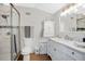 Bright bathroom with white cabinetry, double vanity, and glass shower at 4640 Hickory Tree Rd, St Cloud, FL 34772