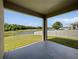 Covered back porch with views of the fenced-in yard and adjacent lake at 4841 Hickory Stream Ln, Mulberry, FL 33860