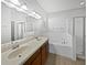 Primary bathroom featuring double sinks, a soaking tub, and a glass-enclosed shower at 4841 Hickory Stream Ln, Mulberry, FL 33860