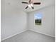 Bright bedroom featuring neutral carpet, a ceiling fan, and a window with green outdoor views at 4841 Hickory Stream Ln, Mulberry, FL 33860