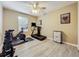 Exercise room with wood-look floors, weights, treadmill, exercise bike, and natural light from windows at 5050 Shorewood Landing Ln, Oviedo, FL 32765