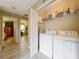 Functional laundry room with modern washer and dryer units, with easy access to bedroom and exercise room at 5050 Shorewood Landing Ln, Oviedo, FL 32765