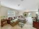 Spacious living room with tile floors, a large sofa, and sliding glass doors to the backyard at 5050 Shorewood Landing Ln, Oviedo, FL 32765