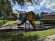 Community playground with slide and merry-go-round and picnic area surrounded by greenery at 5050 Shorewood Landing Ln, Oviedo, FL 32765