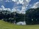 Community pond with reflections of trees and clouds creating a serene and tranquil outdoor scene at 5050 Shorewood Landing Ln, Oviedo, FL 32765