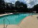 Relaxing community pool with lounge chairs, clear blue water and lush landscaping at 5050 Shorewood Landing Ln, Oviedo, FL 32765