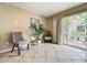 Cozy sitting area with two chairs, a palm tree, and sliding glass doors to the backyard at 5050 Shorewood Landing Ln, Oviedo, FL 32765