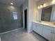 Stylish bathroom with double vanity, grey tile flooring, and a glass-enclosed walk-in shower at 5268 Teirgarten St, St Cloud, FL 34771