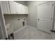 Functional laundry room with ample cabinet space and a utility sink at 5268 Teirgarten St, St Cloud, FL 34771