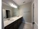 Bright bathroom featuring double sinks, a wide mirror, and a wood-look tile floor at 5330 Center Lake, St Cloud, FL 34771