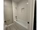 Clean bathroom with a tub, shower, white subway tiles, and gray flooring at 5330 Center Lake, St Cloud, FL 34771