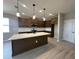Modern kitchen with a large island, quartz countertops, dark wood cabinets and stainless steel appliances at 5330 Center Lake, St Cloud, FL 34771