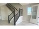 Carpeted staircase with wrought iron balusters, complemented by wood-look tile flooring and natural light at 5330 Center Lake, St Cloud, FL 34771