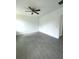 New bedroom featuring gray tiled floors, white walls, ceiling fan, and new window at 563 Winogene Ave, Umatilla, FL 32784