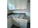 A new kitchen features white cabinets, stainless hardware, and unique marble countertops at 563 Winogene Ave, Umatilla, FL 32784