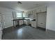 Bright new kitchen featuring white cabinets, gray floors, marble countertops, and a window at 563 Winogene Ave, Umatilla, FL 32784