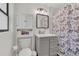 Bathroom with gray vanity, framed mirror, medicine cabinet and decorative butterfly shower curtain at 5943 Sunderland Dr, Orlando, FL 32812