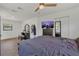 The spacious main bedroom is filled with light and has tile floors, a ceiling fan, and a view of the backyard at 5943 Sunderland Dr, Orlando, FL 32812