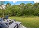 Secluded backyard with a lush green lawn, patio area, and serene wooded backdrop at 6672 S Goldenrod Rd # 132B, Orlando, FL 32822
