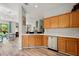 Kitchen showcasing stainless steel dishwasher, light wood cabinets, white countertops, and wood floors at 6672 S Goldenrod Rd # 132B, Orlando, FL 32822