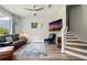 A stylish living room features a cozy couch, TV, modern ceiling fan, and stairway with wood floors at 6672 S Goldenrod Rd # 132B, Orlando, FL 32822