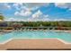Community swimming pool with sun loungers and landscaping, with a lake in the background at 6672 S Goldenrod Rd # 132B, Orlando, FL 32822