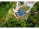 Aerial view of the home featuring an enclosed pool, landscaping and lush greenery at 810 Alex Ln, Deltona, FL 32738
