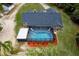 Aerial view of a home with an enclosed pool, deck, landscaped yard, and lush greenery at 810 Alex Ln, Deltona, FL 32738