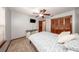 Bedroom features a ceiling fan, a wooden closet door, a mounted TV, and neutral decor at 810 Alex Ln, Deltona, FL 32738