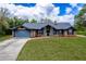 Charming brick home featuring a spacious front lawn and a two-car garage at 810 Alex Ln, Deltona, FL 32738