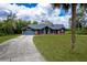 Well-maintained front yard of a charming brick home with attached garage and inviting landscaping at 810 Alex Ln, Deltona, FL 32738