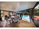 Covered patio area with outdoor dining set, grill, and view of pool and backyard at 810 Alex Ln, Deltona, FL 32738