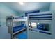 Bright bedroom featuring two sets of gray bunk beds with blue bedding and matching decor at 8110 Princess Palm Ln, Kissimmee, FL 34747