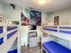 room featuring two bunk beds, neutral gray walls, and Peter Pan-themed decor at 8110 Princess Palm Ln, Kissimmee, FL 34747