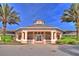View of the clubhouse at a low angle, tall palm trees are on either side of it at 8110 Princess Palm Ln, Kissimmee, FL 34747