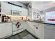 The kitchen is decorated with white appliances, grey wood floors, white cabinets and granite countertops at 8110 Princess Palm Ln, Kissimmee, FL 34747