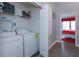 Laundry area features a washer, dryer, shelves, and storage cabinet, conveniently located near the bedroom at 8110 Princess Palm Ln, Kissimmee, FL 34747