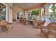 Covered patio with wicker furniture, including chairs and a table, offering an ideal outdoor relaxation space at 8110 Princess Palm Ln, Kissimmee, FL 34747