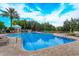 Sparkling blue swimming pool surrounded by comfortable lounge chairs and lush tropical landscaping at 8110 Princess Palm Ln, Kissimmee, FL 34747