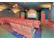 Home theater features tiered seating, a large screen, and ambient lighting for a cinematic experience at 8110 Princess Palm Ln, Kissimmee, FL 34747